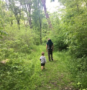 son hiking while dad carries daughter
